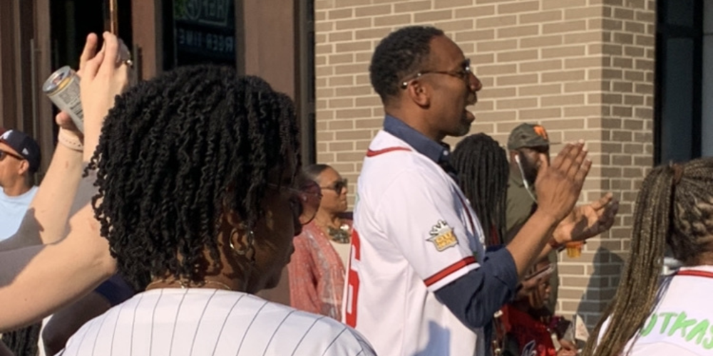 Atlanta Mayor Andre Dickens claps and signs along during Biological Misfits' set of OutKast songs in the plaza adjacent to Truist Park on May 25, 2023.