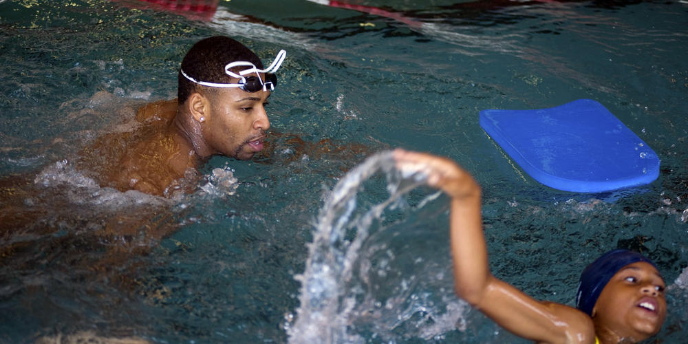 Olympic swimmer Cullen Jones, left, teaches Jamiya Hoyt, 9, of Houston, and four other students from Johnson Elementary School some basic swimming techniques at MacArthur Senior High School on Tuesday, May 19, 2009, in Houston. Cullen is helping launch a national water safety campaign.