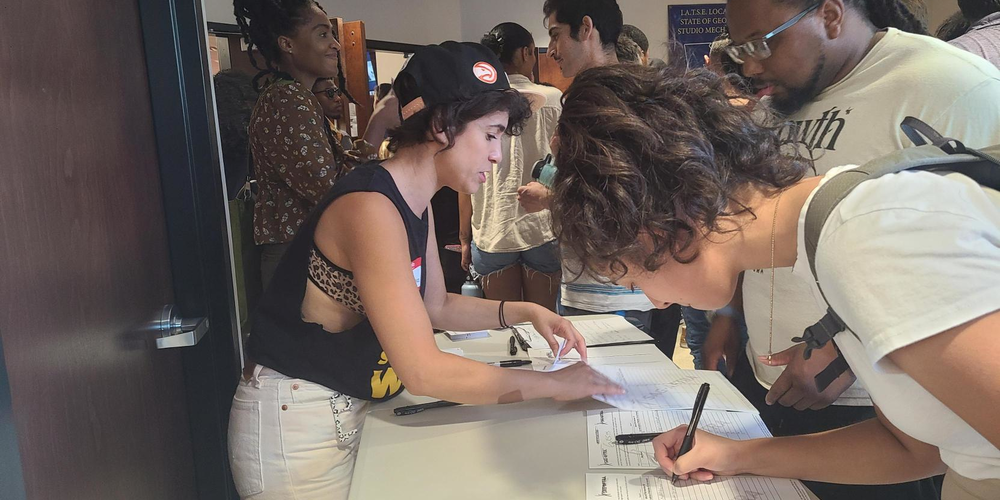 Atlanta actress Diany Rodriguez helps non-SAG-AFTRA members sign in as they arrive to the rally.