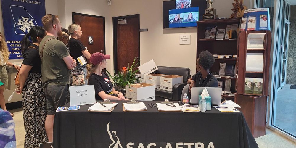 Supporters stand in the lobby by a sign-in table to hear remarks from SAG-AFTRA President Fran Drescher, who joined the Atlanta rally via Zoom.