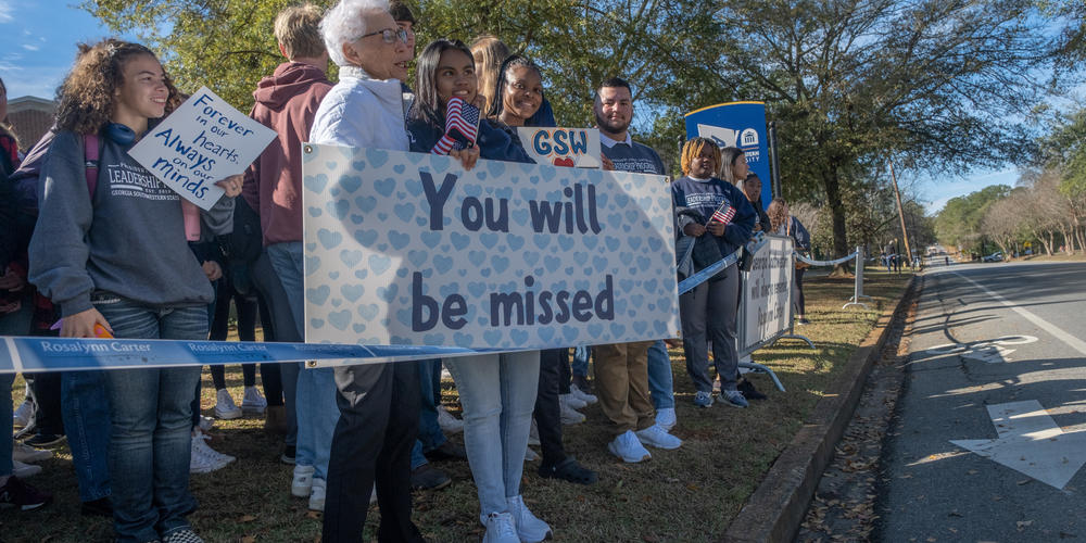 Students and teachers from Georgia Southwestern State University, Rosalynn Carter's alma mater, watch as a motorcade carrying the former first lady to Atlanta makes its way through campus.