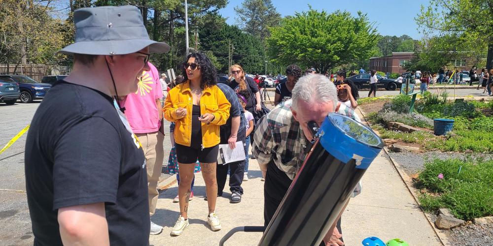 Visitors line up to use the telescope at Fernbank Science Center April 8, 2024 to view the solar eclipse.