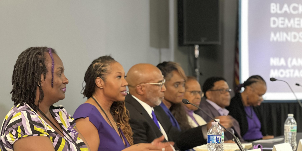 Panelists at the Black Dementia Minds discussion talk about living with neurocognitive disorders. Terry Montgomery sits in the center of the panel. 