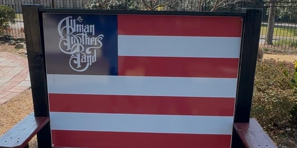 A bench with the Allman Brothers Band logo sits in the front yard of The Big House in Macon, Ga.