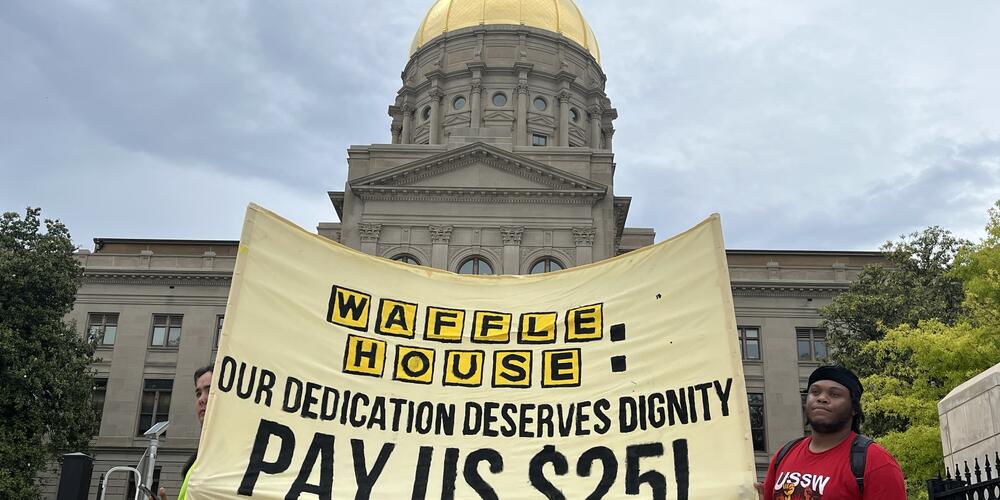 A gold banner says "Waffle House: Our dedication deserves dignity pay us $25!"