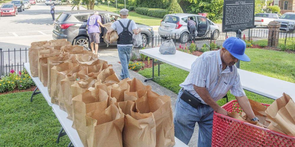 Volunteers share bags of groceries Wednesday with some of the close to 500 families who access food aid at the St. Peter Claver Catholic Church in Macon every week. The St. Peter Claver pantry is just one of over 150 pantries affiliated with the Middle Georgia Community Food Bank. 