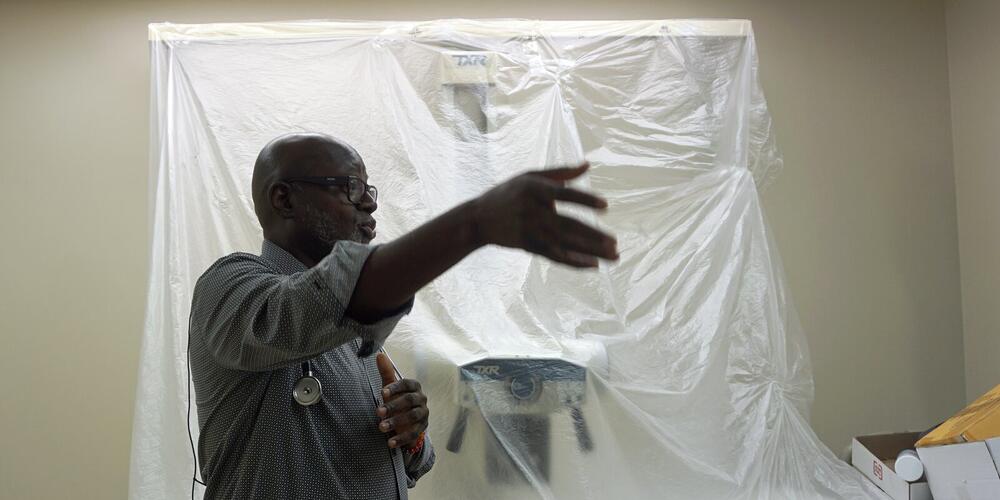 Dr. Alawode Oladele in front of a new X-ray machine that is part of DeKalb Public Health's new tuberculosis clinic. The county has the highest rate of TB infections among Georgia counties. (Rebecca Grapevine / Healthbeat)