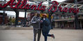 Lee and Shenelle Brown pose in front of the Atlanta Braves sign outside Truist Park. They were among the first fans to arrive early Friday, Nov. 5, 2021, to celebrate the team's World Series victory.