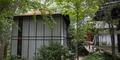A wooden walkway leads from the carport to the house.