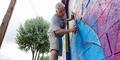 Atlanta Crossroads Mural Festival painter working on mural. (Isadora Pennington/Rough Draft Atlanta)