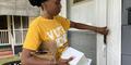 Kareemah Hanifa places a flier in the door of a house in Augusta as part of the vote in my honor canvassing effort.
