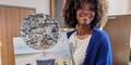 An Emory student displays a collage created from the dust jackets of books donated to the university by Elton John in 2024.