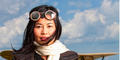 Woman pilot in front of barnstorming-era prop plane. Photography by Billy Howard
