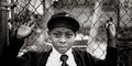 Boy at a chain link fence. Photography by Billy Howard