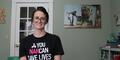 Living Proof Recovery Executive Director Brittney Galvanauskas sits for a portraint wearing a T-shirt that says "Narcan saves lives"