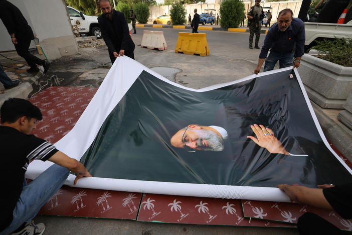 Men prepare to hang a huge portrait of Ebrahim Raisi outside the Islamic republic's embassy in Baghdad during a condolences service on Monday.